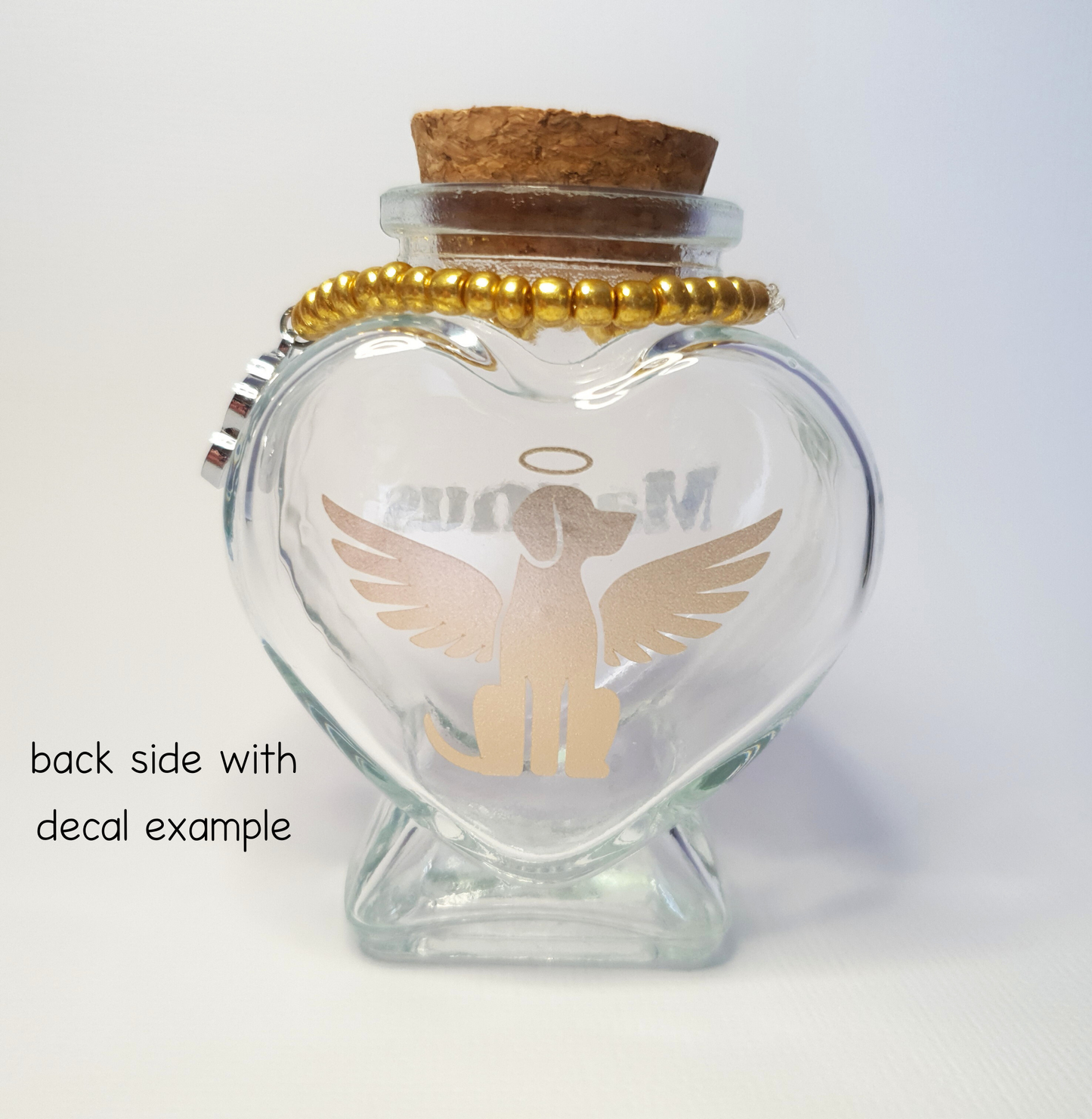 The photo displays the back of the bottle where a gold vinyl decal of a dog with wings and a halo has been placed.