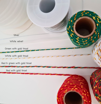 Assorted spools of ribbon in different colours and designs on a white background. 