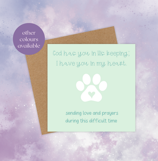 This pet sympathy card has a choice of green or purple backgrounds with a white paw print in the middle. The text at the top reads, “God has you in His keeping; I have you in my heart.” The text at the bottom reads, “Sending love and prayers during this difficult time.”