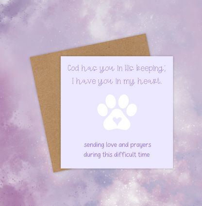 This pet sympathy card has a choice of green or purple backgrounds with a white paw print in the middle. The text at the top reads, “God has you in His keeping; I have you in my heart.” The text at the bottom reads, “Sending love and prayers during this difficult time.”