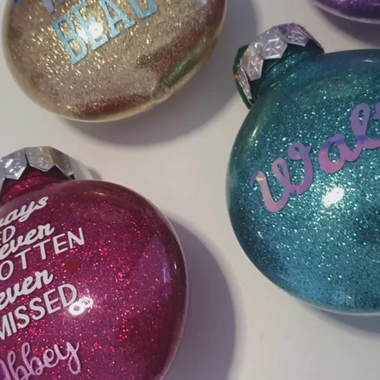 A video displaying the glitter and vinyl text on a range of baubles.