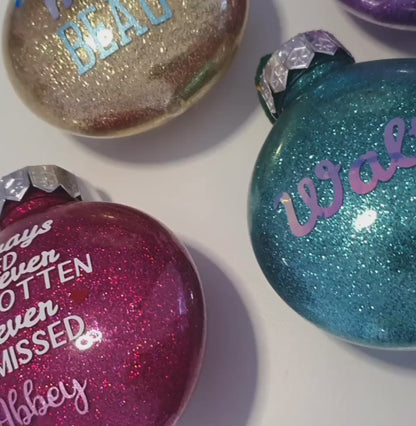 A video displaying the glitter and vinyl text on a range of baubles.